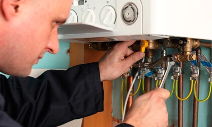 A man working on a boiler, plumbing and heating, property maintenance London